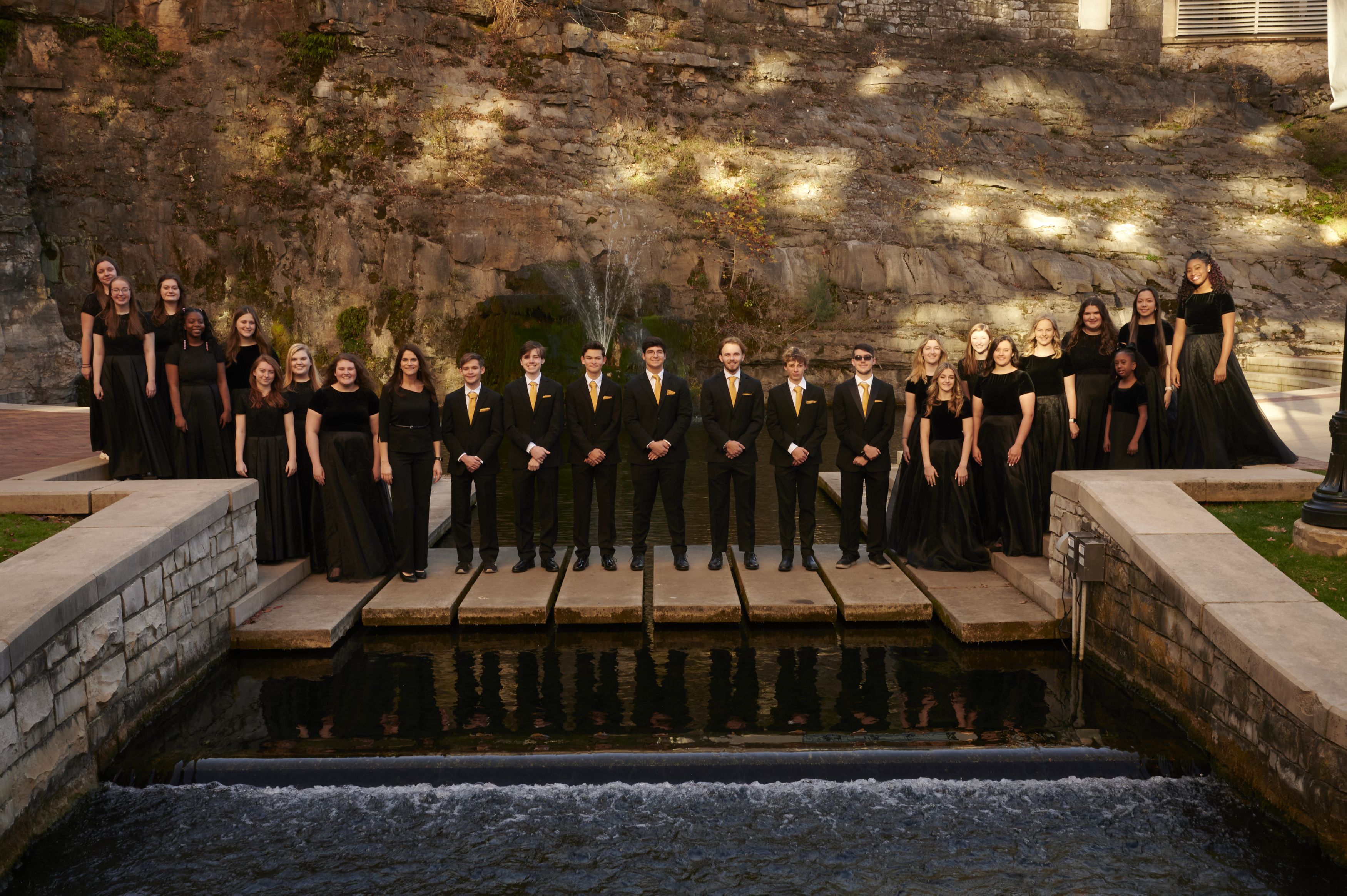 Group of Choir Students dressed in formal clothing, standing in front of a rock formation